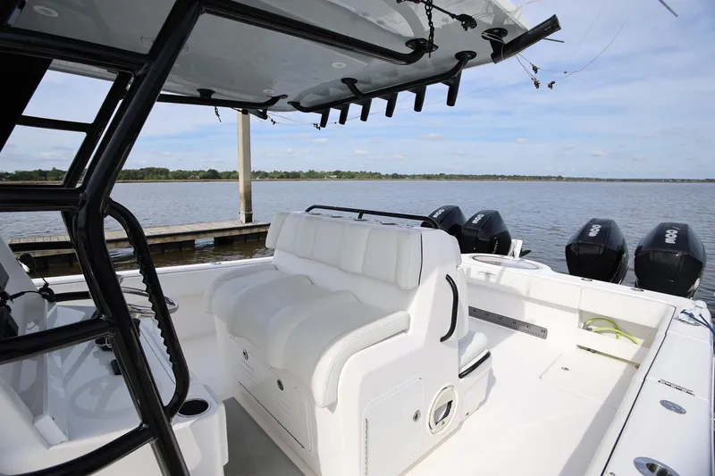 Slide: The Image of 2020 Invincible 35 Catamaran with white seating, docked by a serene lake. - 18