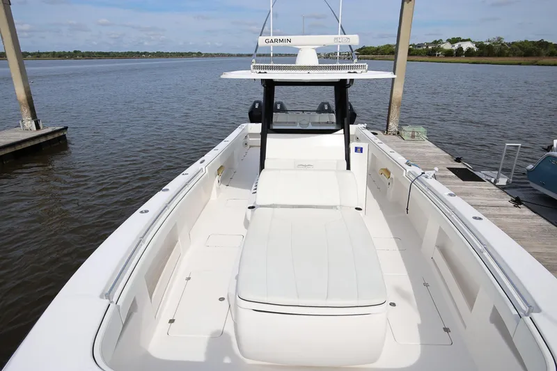 Slide: The Image of 2020 Invincible 35 Catamaran docked, featuring spacious deck and Garmin navigation system. - 32