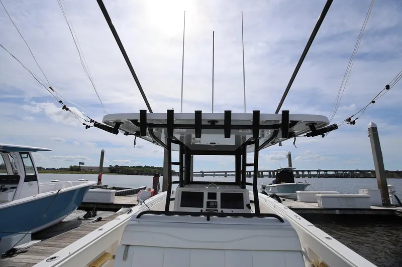 Slide: The Image of 2020 Invincible 35 Catamaran docked, showcasing helm and fishing rods under a clear sky. - 42