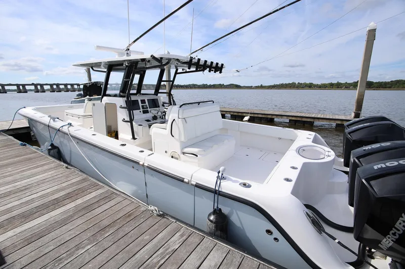 Slide: The Image of 2020 Invincible 35 Catamaran docked, featuring spacious deck and powerful outboard engines. - 7