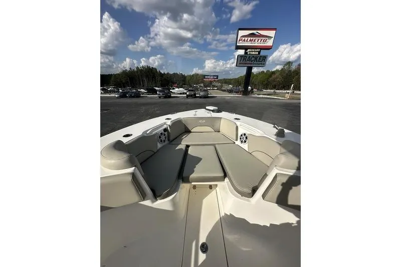 Slide: The Image of 2024 Key West 291 FS boat interior with cushioned seating, parked outdoors under a cloudy sky. - 4