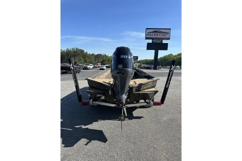 Slide: The Image of 2026 Xpress H18DB boat with 90HP engine, parked outdoors under clear blue sky. - 3