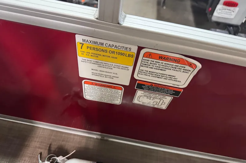 Slide: The Image of 2024 Sun Tracker Bass Buggy 16 XL Select capacity and warning labels on red panel. - 10