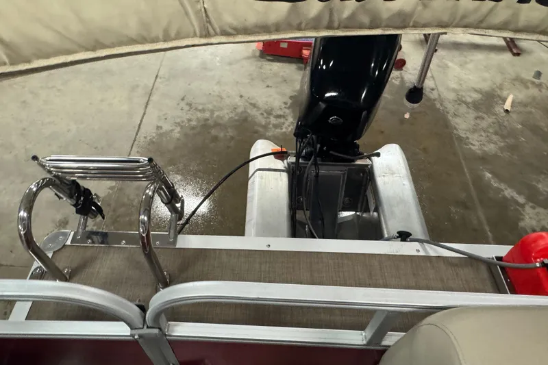 Slide: The Image of 2024 Sun Tracker Bass Buggy 16 XL Select boat with motor and ladder in a garage. - 11