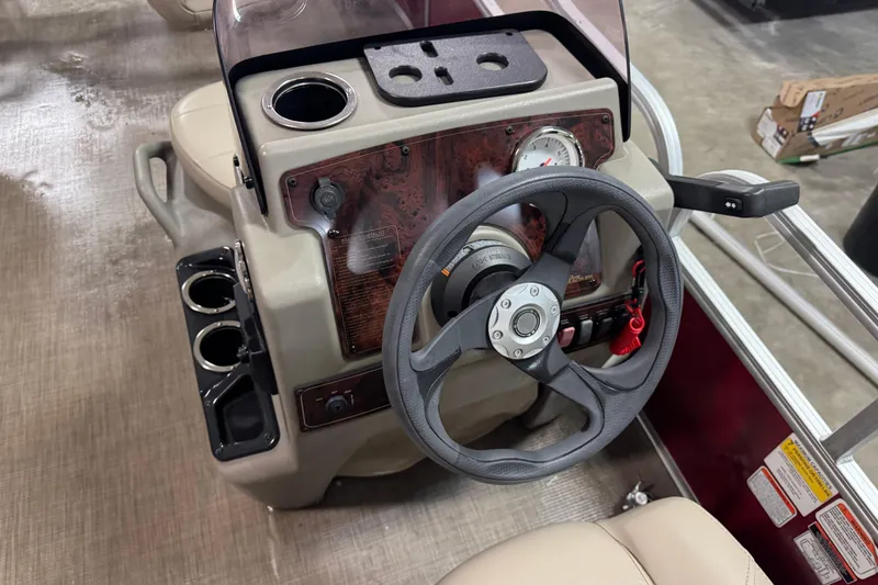 Slide: The Image of 2024 Sun Tracker Bass Buggy 16 XL Select steering console with cup holders and controls. - 9