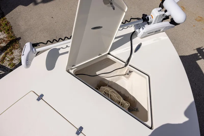 Slide: The Image of 2025 Hewes Redfisher 21 boat with open storage compartment and Minn Kota trolling motor. - 11