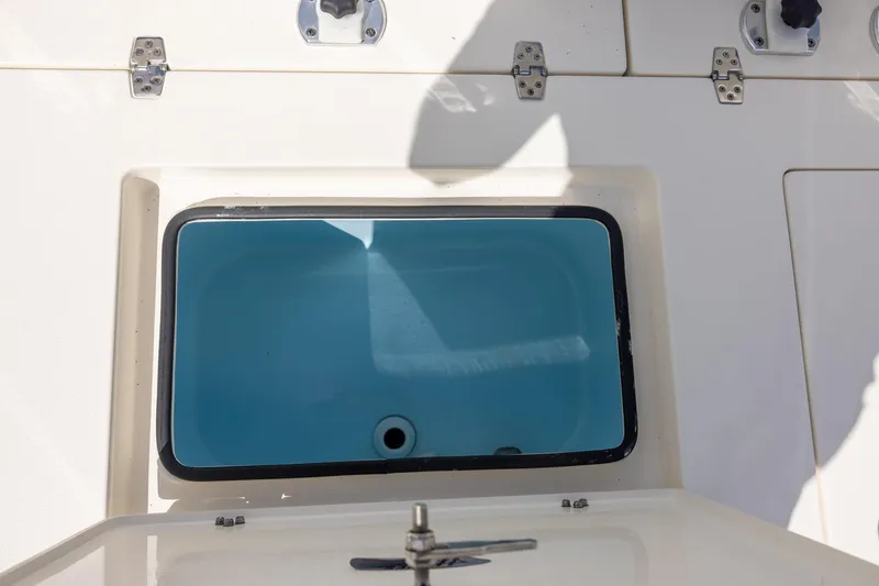 Slide: The Image of Livewell compartment on a 2025 Hewes Redfisher 21 boat, featuring a blue interior. - 13