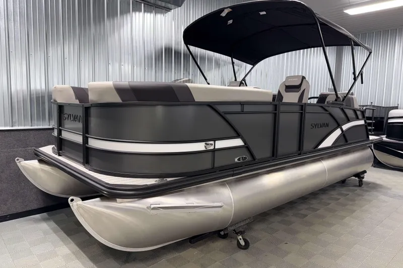 Slide: The Image of 2026 Sylvan L1 LZ pontoon boat in showroom, featuring sleek design and comfortable seating. - 24