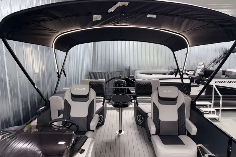 Slide: The Image of 2026 Sylvan L1 LZ pontoon boat with canopy and luxurious seating in showroom. - 32