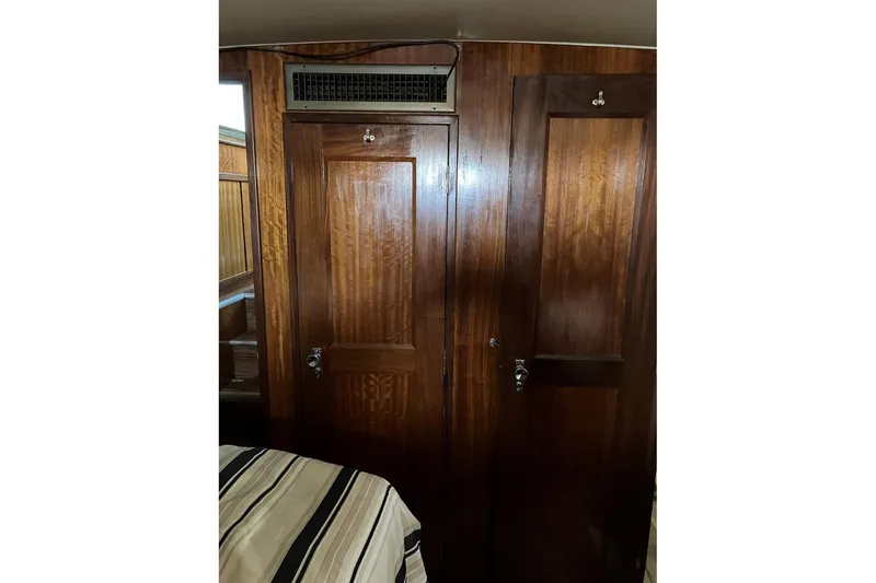 Slide: The Image of Interior of 1972 Hatteras 38 Double Cabin with wooden doors and striped bedding. - 10