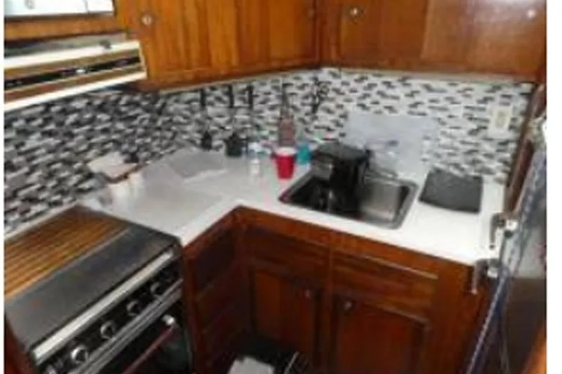 Slide: The Image of 1972 Hatteras 38 Double Cabin kitchen with wood cabinets and modern backsplash. - 5