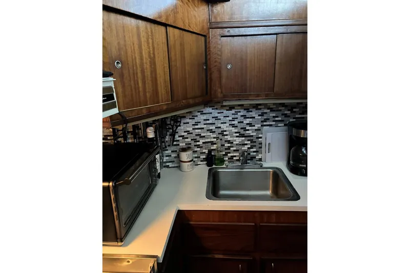 Slide: The Image of 1972 Hatteras 38 Double Cabin kitchen with wood cabinets and modern backsplash. - 6