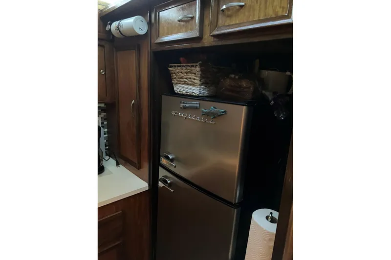 Slide: The Image of 1972 Hatteras 38 Double Cabin kitchen with stainless steel fridge and wooden cabinets. - 7