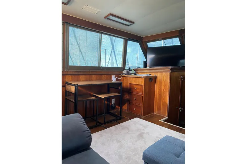 Slide: The Image of Interior of 1972 Hatteras 38 Double Cabin with wooden furniture and large windows. - 8