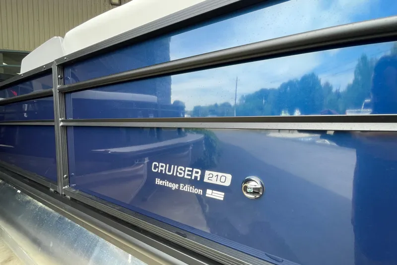 Slide: The Image of 2026 Harris Cruiser 210 SLDH Heritage Edition pontoon boat with blue exterior detailing. - 14