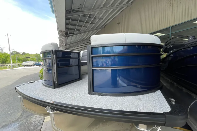 Slide: The Image of 2026 Harris Cruiser 210 SLDH pontoon boat with sleek blue exterior under a canopy. - 16