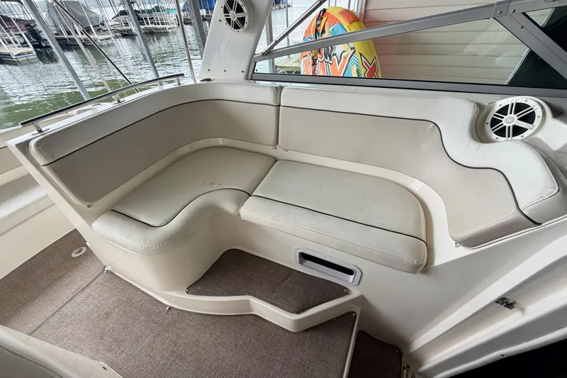 Slide: The Image of 2006 Rinker 300 Express Cruiser interior seating with beige upholstery and speaker. - 10