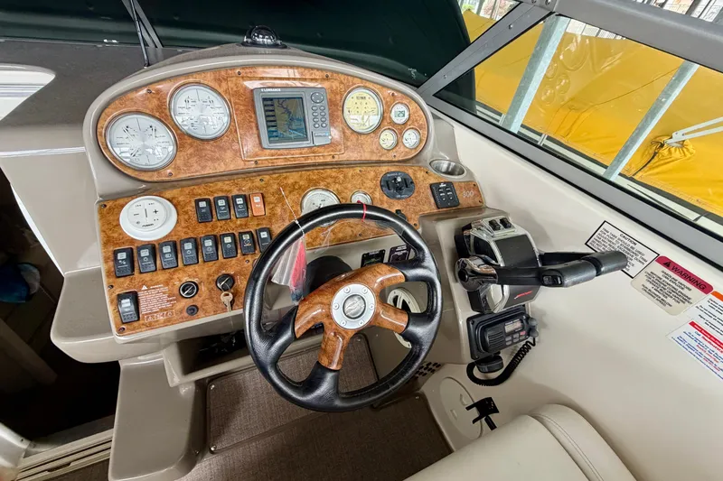 Slide: The Image of 2006 Rinker 300 Express Cruiser dashboard with gauges, controls, and steering wheel. - 12