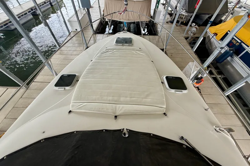 Slide: The Image of 2006 Rinker 300 Express Cruiser docked, showcasing spacious deck and sleek design. - 17