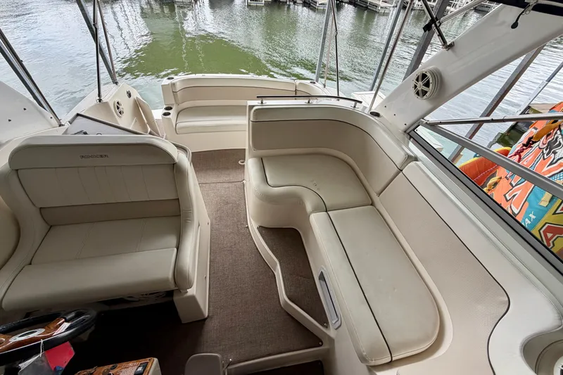 Slide: The Image of 2006 Rinker 300 Express Cruiser interior with beige seating and lake view. - 18