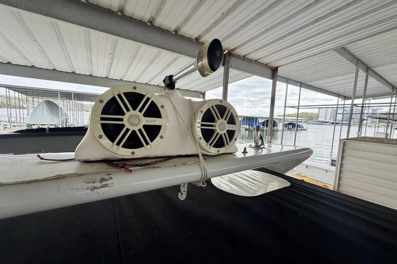 Slide: The Image of 2006 Rinker 300 Express Cruiser with mounted speakers in a covered marina. - 19