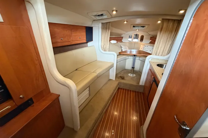 Slide: The Image of 2006 Rinker 300 Express Cruiser interior with seating, table, and wood accents. - 23
