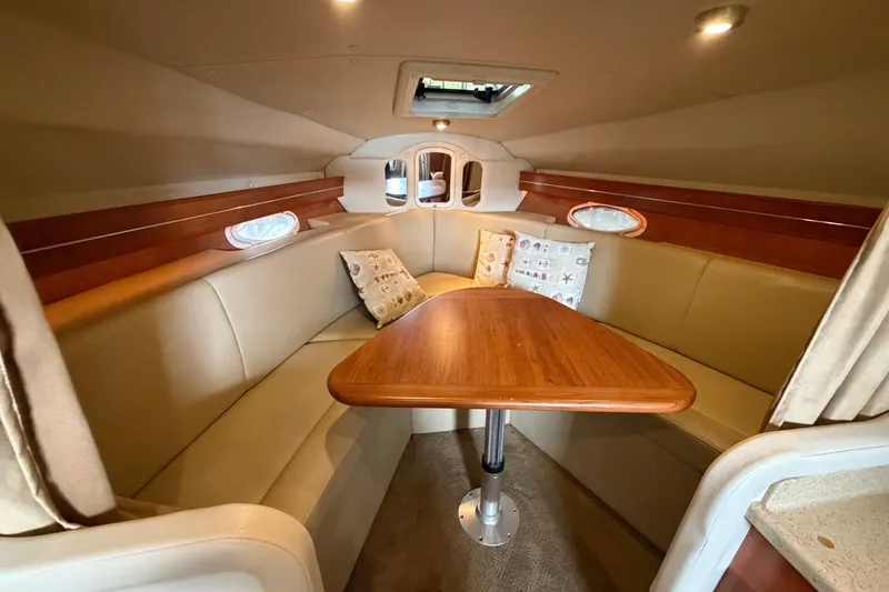 Slide: The Image of Interior of 2006 Rinker 300 Express Cruiser with cozy seating and wooden table. - 26