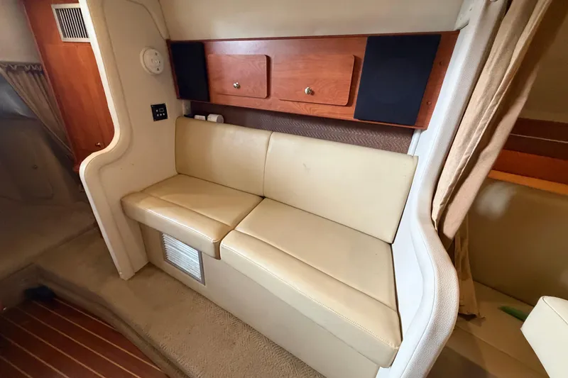 Slide: The Image of Interior of a 2006 Rinker 300 Express Cruiser with beige seating and wooden cabinetry. - 27