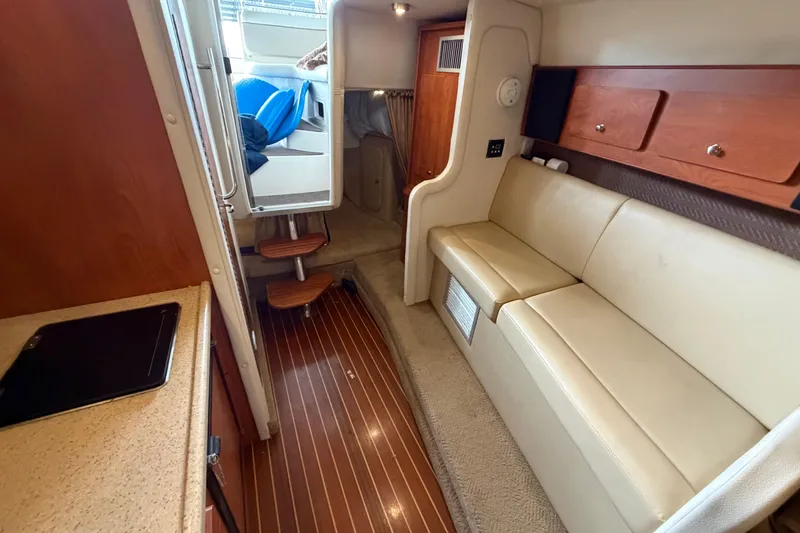 Slide: The Image of Interior of 2006 Rinker 300 Express Cruiser with beige seating and wooden accents. - 28