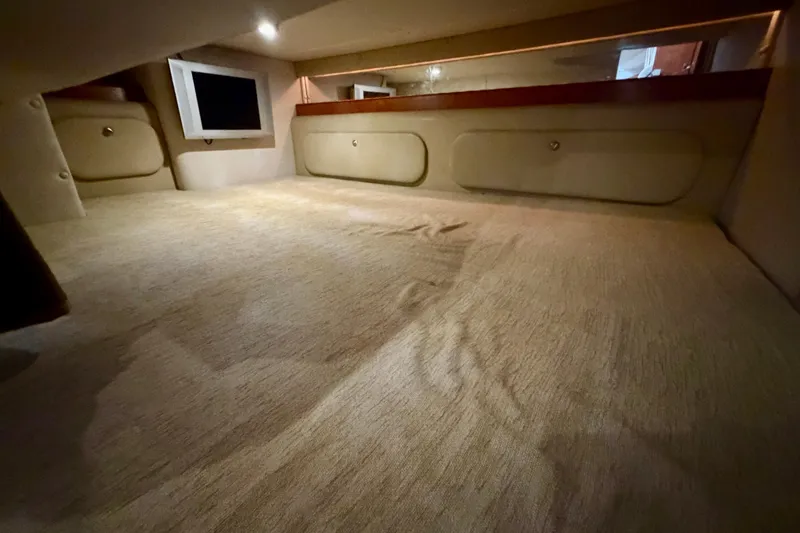 Slide: The Image of Interior cabin of 2006 Rinker 300 Express Cruiser with carpeted flooring and storage compartments. - 31