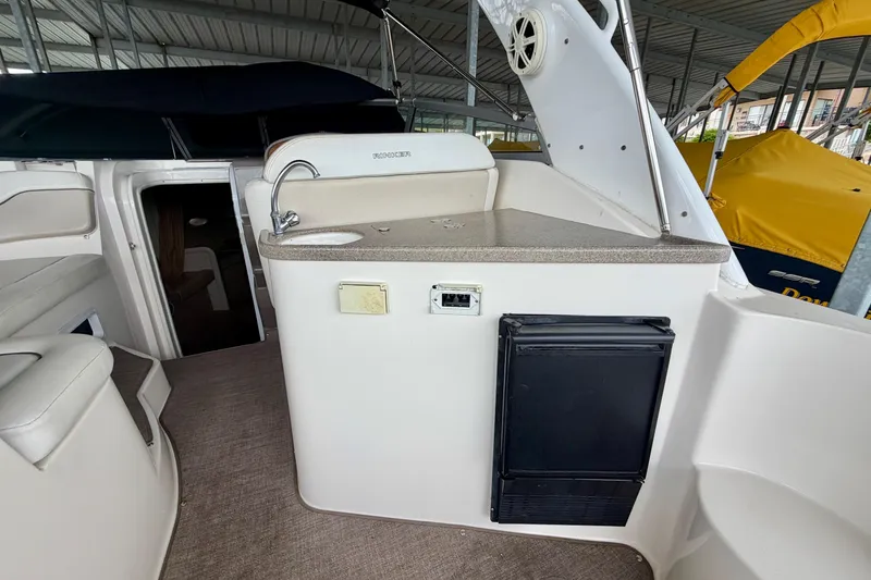 Slide: The Image of 2006 Rinker 300 Express Cruiser interior with kitchenette and seating area. - 5