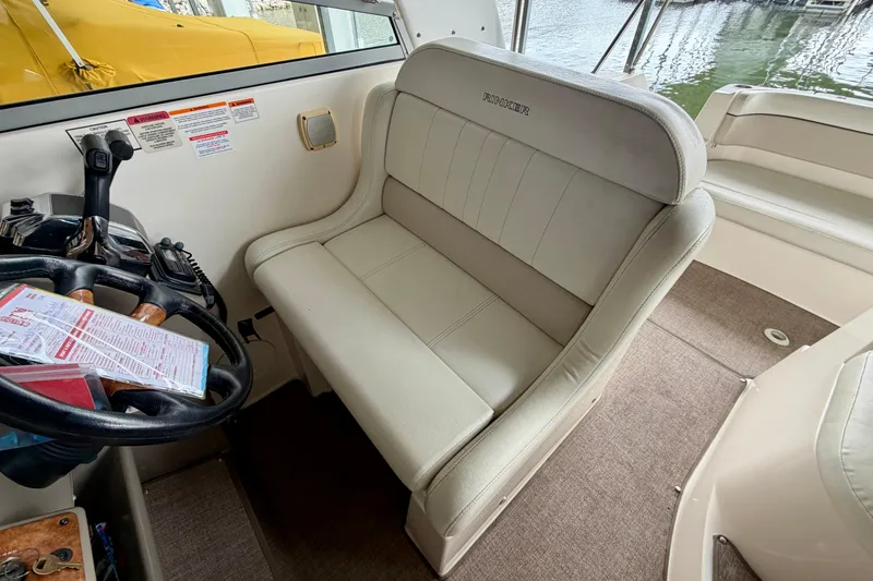 Slide: The Image of 2006 Rinker 300 Express Cruiser cockpit with beige seating and steering wheel. - 9