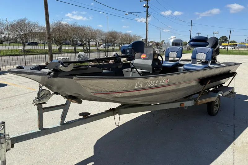 Slide: The Image of 1996 Duracraft 16 SC boat on trailer, parked outdoors under clear sky. - 3