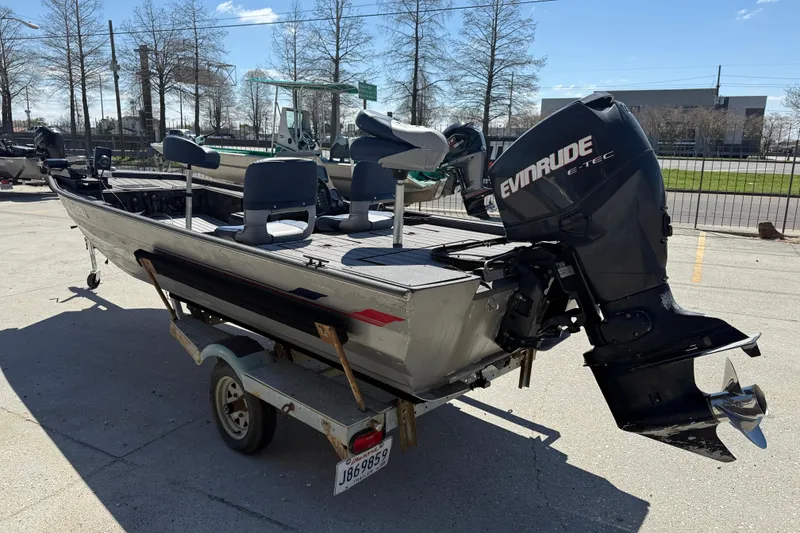 Slide: The Image of 1996 Duracraft 16 SC boat with Evinrude motor on trailer, parked outdoors. - 4
