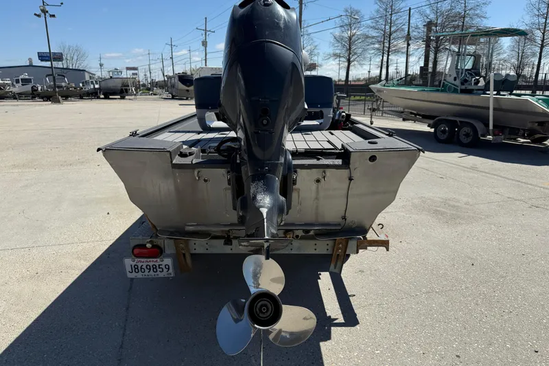 Slide: The Image of 1996 Duracraft 16 SC boat with outboard motor, parked on a trailer in a lot. - 5