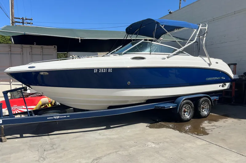 The Image of 2007 Chaparral 256 SSi boat on trailer, blue and white exterior, parked outdoors. - 0