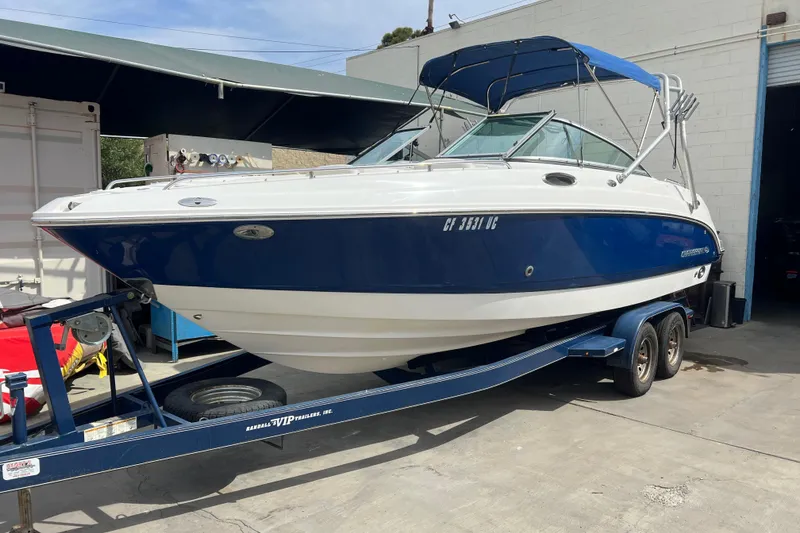 Slide: The Image of 2007 Chaparral 256 SSi boat on trailer, blue and white exterior, parked outdoors. - 19