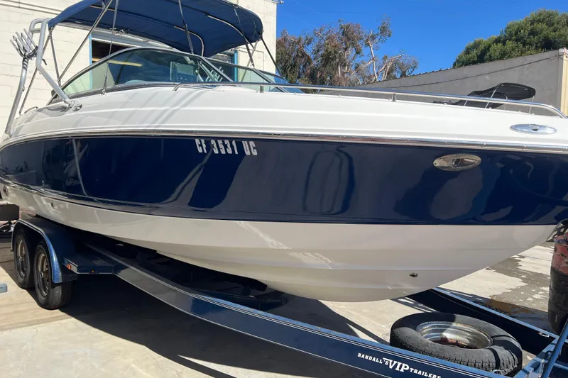 Slide: The Image of 2007 Chaparral 256 SSi boat on trailer, blue and white exterior, parked outdoors. - 2