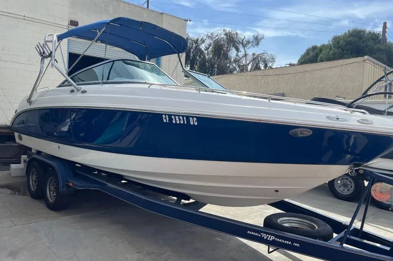 Slide: The Image of 2007 Chaparral 256 SSi boat on trailer, blue and white exterior, parked outdoors. - 20