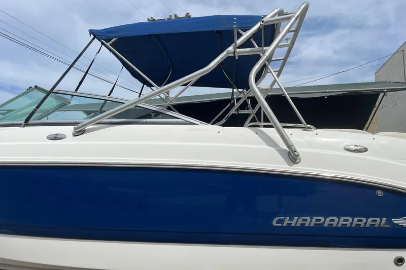 Slide: The Image of 2007 Chaparral 256 SSi boat with blue and white exterior, featuring a canopy and ladder. - 3