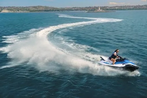Slide: The Image of 2026 Kawasaki Jetski STX 160X speeding on open water, creating a dynamic wake. - 9