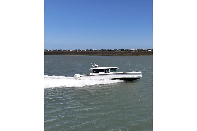 Slide: The Image of 2019 Axopar 37 XC Cross Cabin cruising on open water. - 3