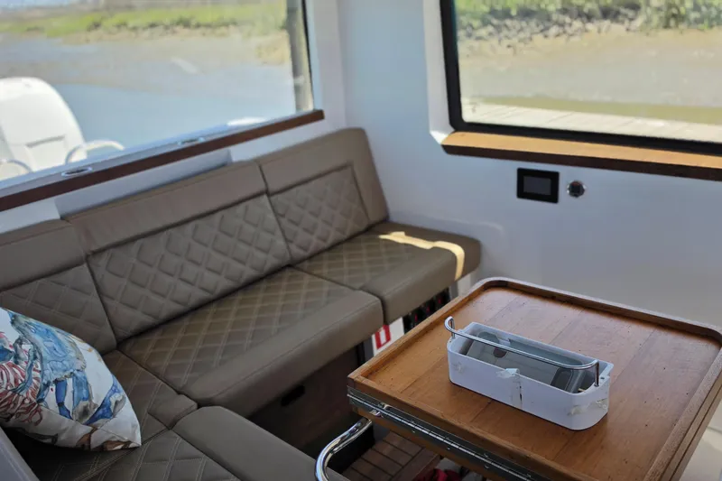 Slide: The Image of Interior of 2019 Axopar 37 XC Cross Cabin with beige seating and wooden table. - 6