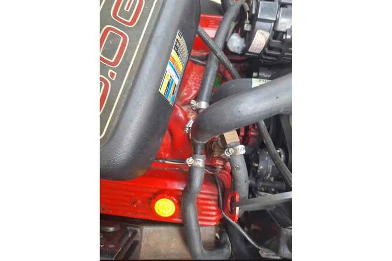 Slide: The Image of Engine components of a 2009 Glastron GT 249 boat, featuring hoses and clamps. - 14