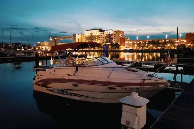 Slide: The Image of 2009 Glastron GT 249 boat docked at marina during evening, city lights in background. - 6