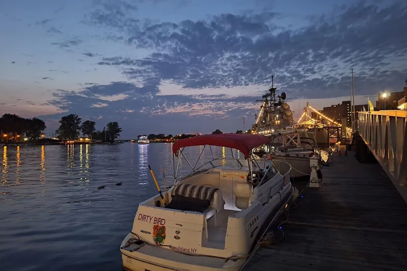 Slide: The Image of 2009 Glastron GT 249 boat docked at sunset with scenic waterfront view. - 7