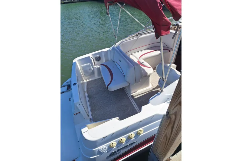 Slide: The Image of 2009 Glastron GT 249 boat interior with red canopy and seating, docked on water. - 8