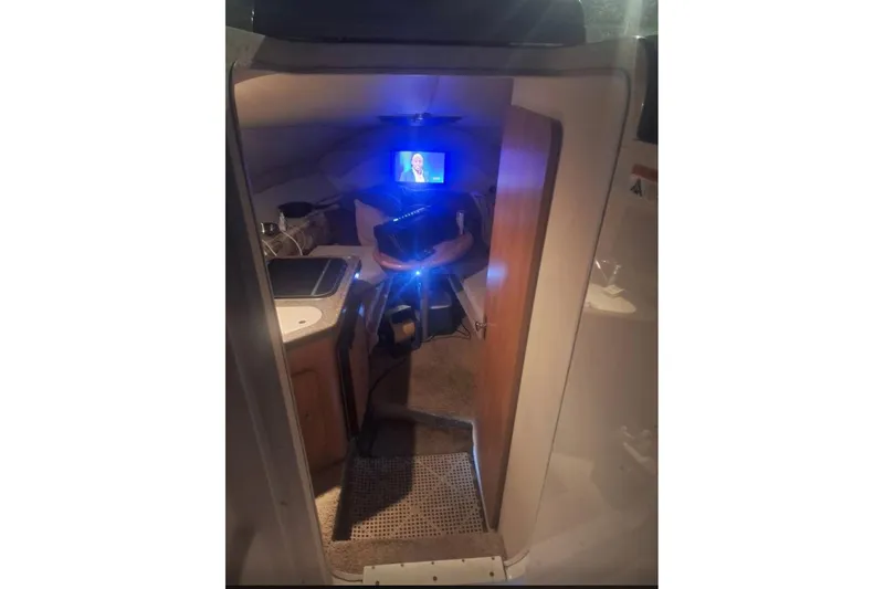 Slide: The Image of Interior of 2009 Glastron GT 249 boat cabin with TV and kitchenette. - 9