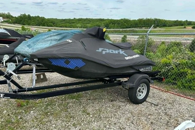 Slide: The Image of 2022 Sea-Doo Spark Trixx 2up jet ski covered on trailer, parked outdoors. - 13