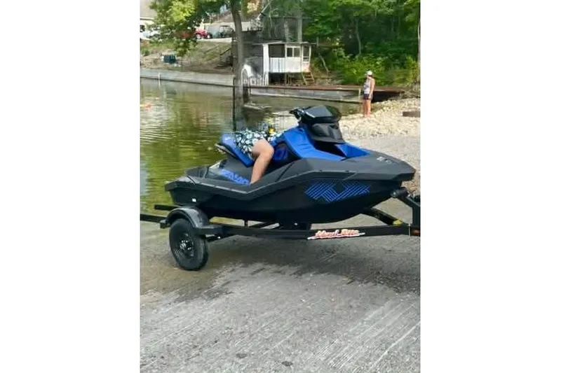Slide: The Image of 2022 Sea-Doo Spark Trixx 2up on trailer by a lakeside. - 2